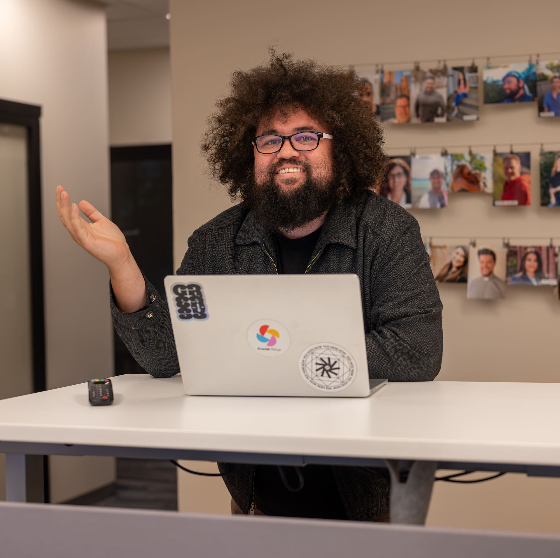A Granite City member working at a standing desk beside the member photo wall in Folsom